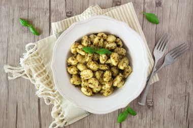 Gnocchi pesto sos ile tabak. Ahşap arka plan üzerinde üstten görünüm.