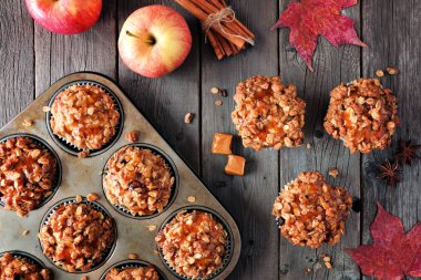 Sonbahar düz sahne sıcak apple ile karamelli çörek yatıyordu. Görünüm tablo sahne rustik ahşap arka plan üzerinde yukarıda.