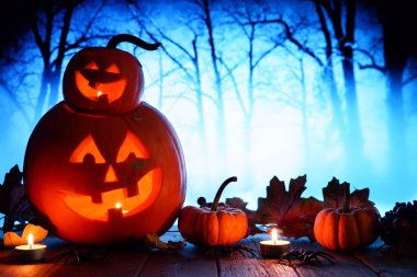 Eğlenceli Halloween Jack o fener. Bir mavi korkunç orman arka plan ile gece çekimi.