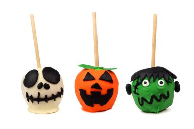 Beyaz bir arka plan üzerinde izole üç Cadılar Bayramı şeker elma. İskelet, jack o fener ve canavar.