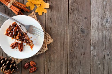 Cevizli karamelli cheesecake dilim. Rustik ahşap arka plan üzerinde kopya alanı ile yan sınır. Sonbahar tatlı.