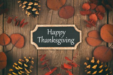 Bir rustik ahşap arka plan üzerinde mutlu Şükran Günü chalkboard tebrik kartı ile kırmızı sonbahar yaprakları