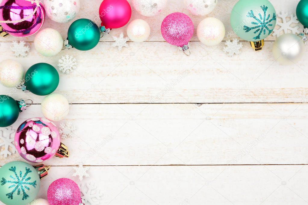Pastel Christmas bauble corner border over a bright white wood background