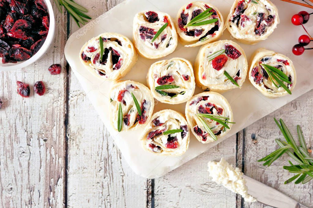 Cranberry, cream cheese pinwheel appetizers. Holiday food concept. Top view, white table scene.