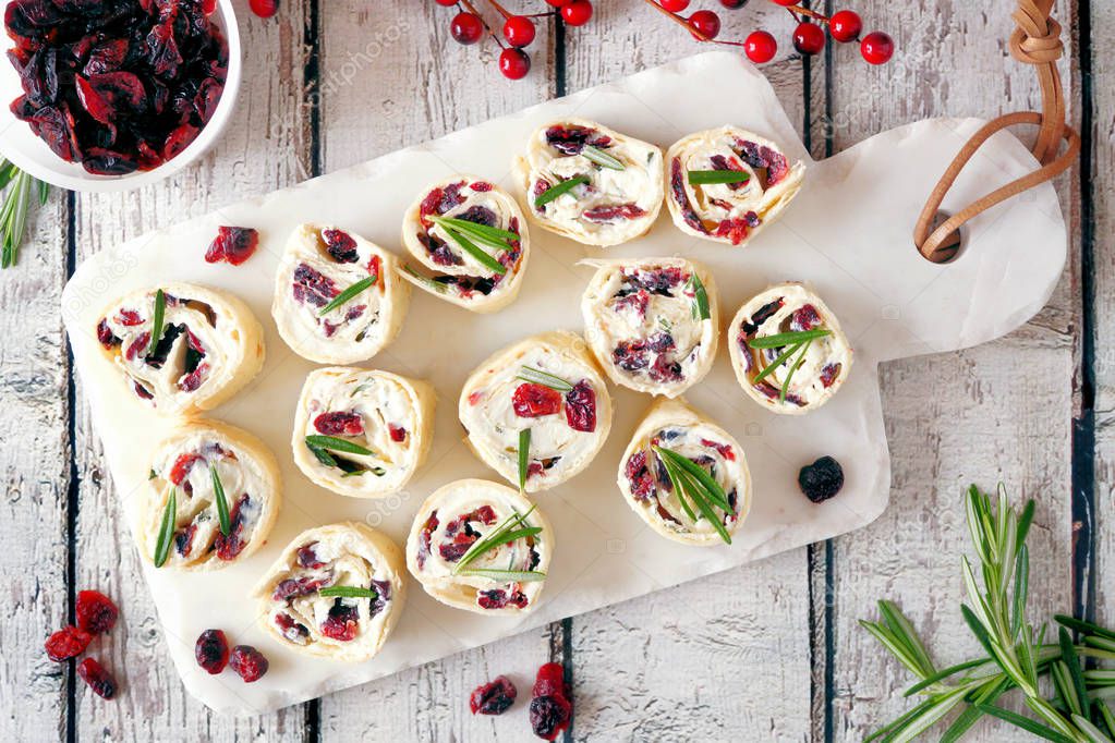 Cranberry, cream cheese roll-up appetizers. Holiday food concept. Top view, on a white background.