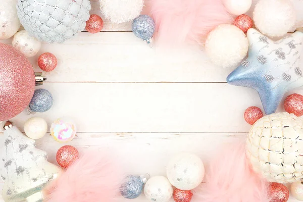 柔和的蓝色和粉红色的圣诞装饰框架在明亮的白色木头背景 — 图库照片