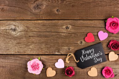Mutlu sevgililer günü köşe sınır hediye etiketi, ahşap kalpleri ve kağıt gül bir rustik ahşap arka plan ile. Kopya alanı.