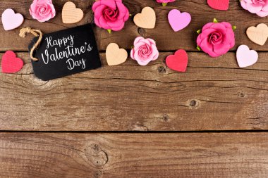 Mutlu sevgililer günü üst kenarlık hediye etiketi, ahşap kalpleri ve kağıt gül bir rustik ahşap arka plan ile. Kopya alanı.