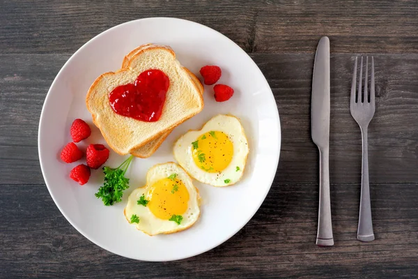 情人节早午餐的概念与心形鸡蛋和烤面包与果酱在一个黑暗的木材背景 顶视图 表格场景 — 图库照片