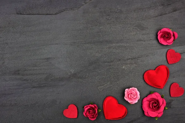 Sevgililer günü köşe sınır kalpler, çiçekler ve karanlık bir taş arka plan kopya alanı ile dekor