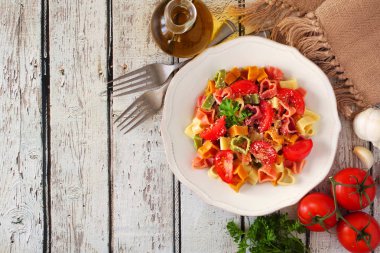 Kalp makarna Sevgililer günü için bir beyaz tahta arka plan üzerinde şeklinde. Üstten görünüm sınır. Tablo sahne malzemelerle.