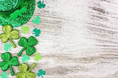 St Patricks Günü yan kenarlığını yoncaları cüce şapkası rustik bir beyaz tahta arka plan üzerinde
