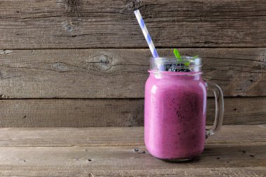 Sağlıklı blackberry güler yüzlü bir rustik ahşap arka plan üzerinde bir mason kavanoza cam