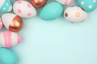 Paskalya köşe kenarlığını pembe, beyaz, mavi ve gül altın Paskalya yumurta pastel mavi bir arka plan karşı. Kopya alanı ile Üstten Görünüm.