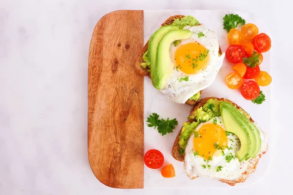 Avocado Toast Met Eieren Tomaten Volkoren Brood Bovenaanzicht Een Marmeren — Stockfoto