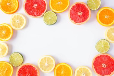 Taze narenciye dilimleri renkli meyve çerçevesi. Üst görünüm, kopya alanı ile beyaz bir arka plan üzerinde düz yatıyordu.