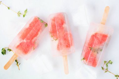 Sağlıklı greyfurt ve kekik buz pops, üst görünümü beyaz mermer arka plan üzerinde dağınık