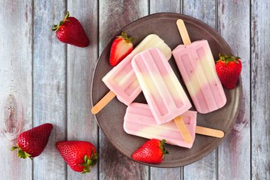 Sağlıklı çilek yaban mersini yoğurt buz açılır, rustik ahşap arka plan üzerinde görünümü yukarıda