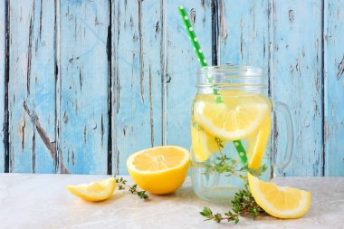 Limon ve kekik bir mason kavanoz cam detoks su aşılanmış. Rustik mavi ahşap arka plan karşı Yaz içki.