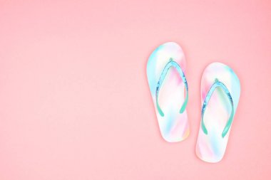 Pembe arka planda yaz parmak arası terlikler. Yaz tatili konsepti. Kopyalama alanı ile üstte görünüm.