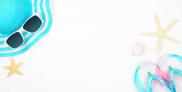Beach accessories on a white wood background. Summer vacation concept banner with copy space. Sunglasses, sea shells, flip flops and blue striped hat.