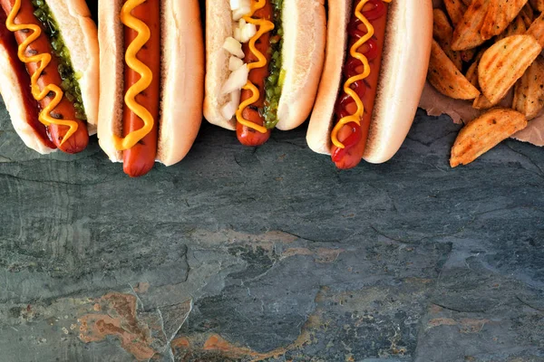 Hot Dogs Toppings Potato Wedges Top Border Overhead View Dark — Stock Photo, Image