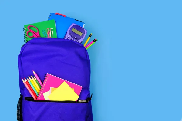 Purpurový Batoh Plný Školních Potřeb Modrém Pozadí Zavřít Pohled Shora — Stock fotografie