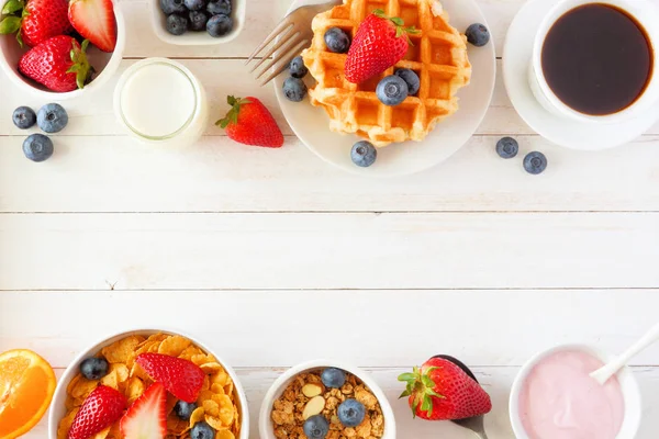 Breakfast food double border. Fruits, cereal, waffles, yogurt, milk and coffee. Top view over a white wood background with copy space.