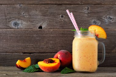 Dağınık meyve ile bir mason kavanoz cam şeftali yüzlü. Rustik koyu ahşap arka plan ile yan görünüm.