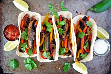 Portobello mantar vegan fajitas. Karanlık bir arka plan üzerinde üst görünüm. Sağlıklı beslenme, bitki bazlı et ikame konsepti.