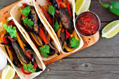 Portobello mantar vegan fajitas. Ahşap arka plan daki üst görünümü kapatın. Sağlıklı beslenme, bitki bazlı et ikame konsepti.