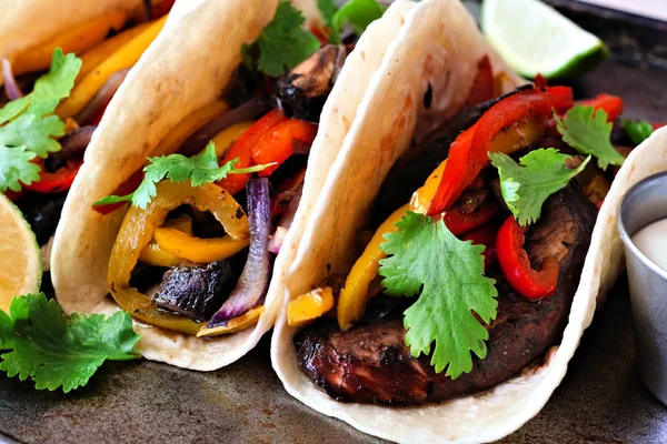 Portobello mushroom vegan fajitas. Close up on a dark background. Healthy eating, plant-based meat substitute concept.