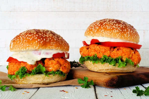 Beyaz ahşap arka plan karşı buffalo soslu karnabahar burger. Sağlıklı beslenme, bitki bazlı et ikame konsepti.