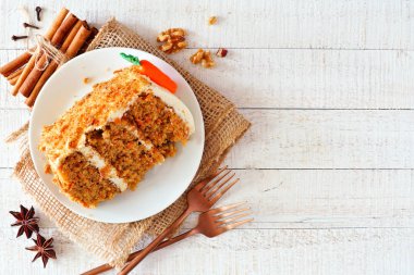 Krem peynir frosting ile ev yapımı havuç kek dilim. Rustik beyaz ahşap arka plan üzerinde görünümü yukarıda.