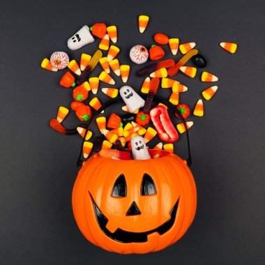 Halloween Jack o Lantern kova dökülen şeker ile, siyah bir arka plan üzerinde üst görünümü