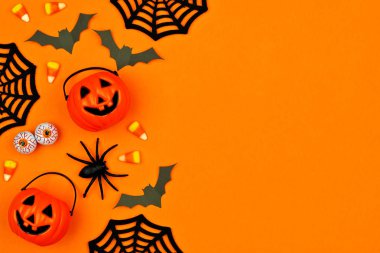 Dağınık şeker ve dekor Cadılar Bayramı yan sınır. Turuncu bir arka plan üzerine kopya alanı ile düz yatıyordu.