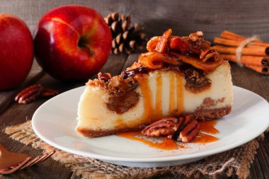 Karamel elmalı cevizli cheesecake. Rustik ahşap arka plan ile yan görünümü kapatın. Sonbahar tatlısı.