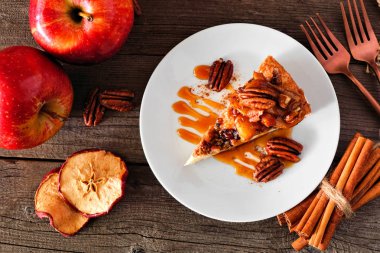 Dilim karamel elma cevizli cheesecake. Rustik ahşap arka plan ile üst görünüm masa sahnesi. Sonbahar tatlısı.