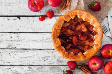 Elma çilek pasta, kopya alanı ile beyaz ahşap arka plan karşı üst görünüm köşe sınırı. Sonbahar gıda konsepti.