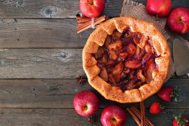 Elma çilek pasta, kopya alanı ile rustik ahşap arka plan karşı üst görünüm yan kenarlık. Sonbahar gıda konsepti.