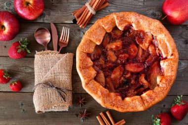 Elma çilek pasta, rustik ahşap arka plan üzerinde havai masa sahnesi. Sonbahar gıda konseptinin servis.