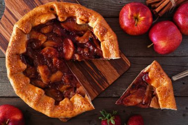 Elma çilek pasta, rustik ahşap arka plan üzerinde kesilmiş dilim ile havai masa sahnesi. Sonbahar gıda konsepti.