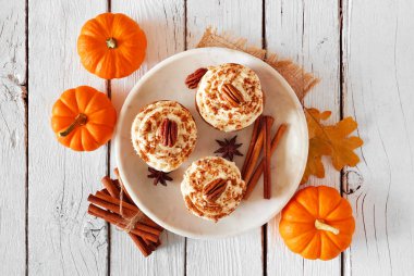 Kremalı frosting ile kabak baharat pekan cupcakes Tabak. Beyaz ahşap arka plan üzerinde en iyi görünüm masa sahnesi.