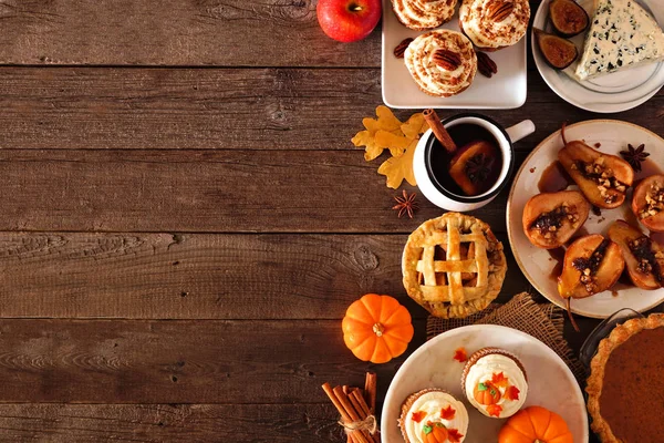 Autumn food side border. Table scene with a selection of pies, appetizers and desserts. Top view over a rustic wood background. Copy space.