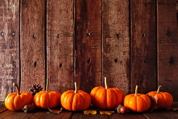 Herbstlicher Rand Aus Kürbissen Und Herbstblättern Seitenansicht Vor Rustikalem Holzhintergrund — Stockfoto