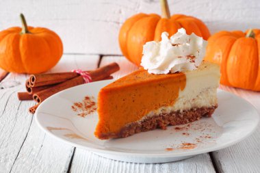 Krem şanti ile kabak pasta cheesecake dilim. Beyaz ahşap arka planda yan görünüm masa sahnesi.
