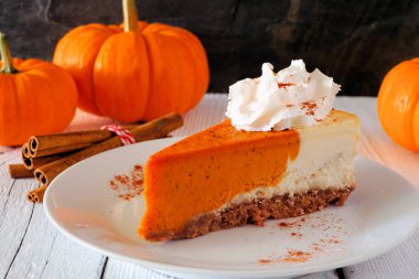 Krem şanti ile kabak cheesecake dilim. Koyu arka planda yan görünüm tablo sahnesi.