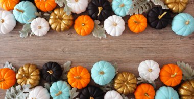 Renkli balkabağı ve gümüş yapraklardan oluşan çift taraflı sınır pankartı ahşap arka planda olacak. Kopyalama alanı ile görünümün üstünde.