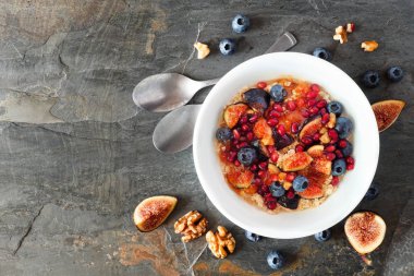 İncirli yulaf ezmesi, yaban mersini, nar ve tatlı reçel. Fotokopi alanı olan bir arkaplan üzerinde üst görünüm. Gıda konsepti.