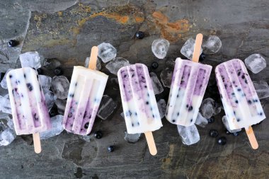 Yaban mersinli vanilyalı yoğurt. Koyu bir arkaplan üzerinde bir satırda görünümün üzerinde.